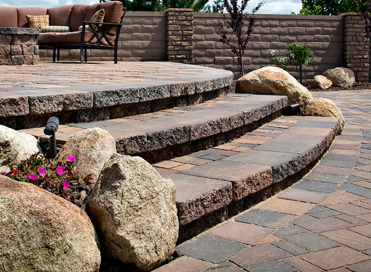 Sturdy paver steps bordered with rocks and plants, offering a functional and stylish outdoor entry.