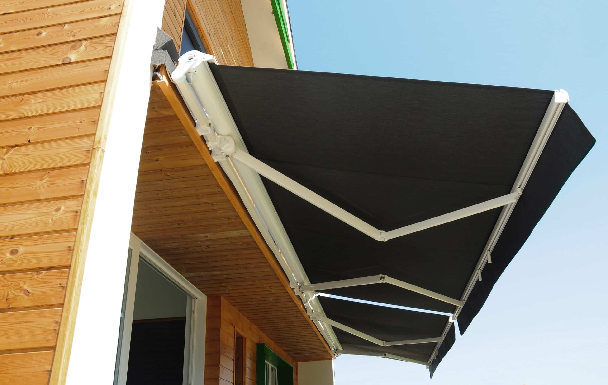 A modern retractable awning extending from a wooden home exterior, offering adjustable shade and sun protection for compact outdoor spaces