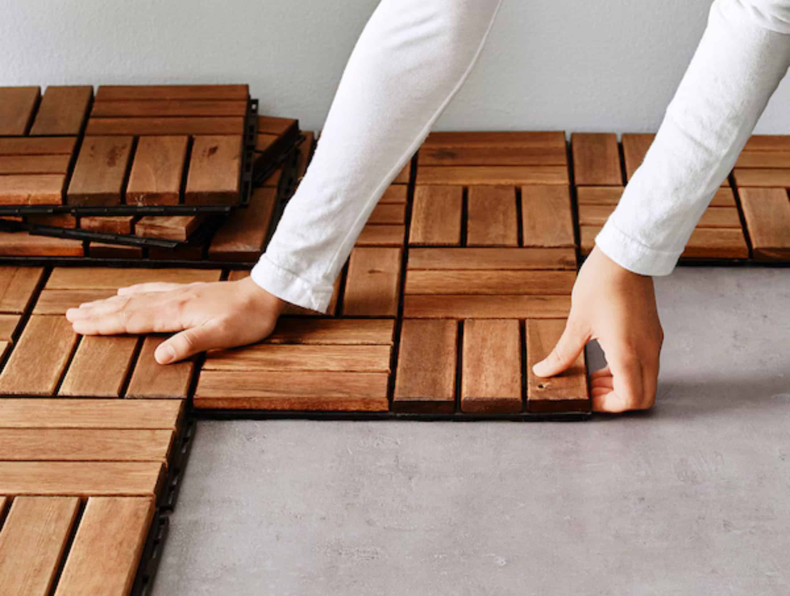 DIY installation of interlocking wood deck tiles, a simple solution for upgrading small backyard floors.